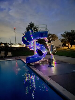 Photo of pool slide at night decorated with lights at Bally Community Pool